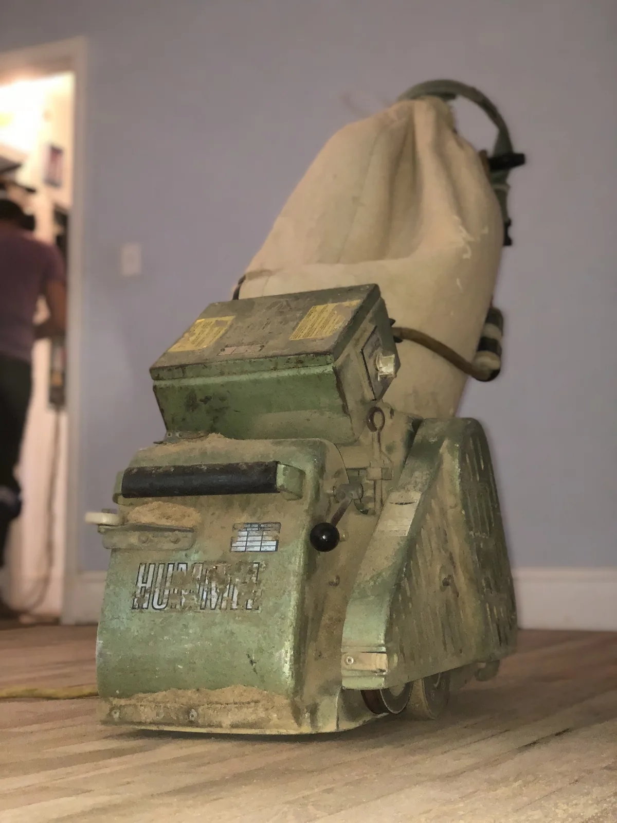 Vintage green drum sander standing on a finished floor