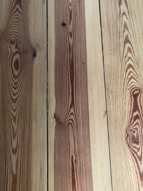 Wide heart pine boards showing dense straight grain and amber resin streaks