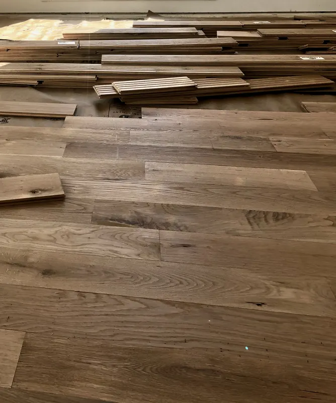 Oak flooring part-laid with loose boards staged across the room
