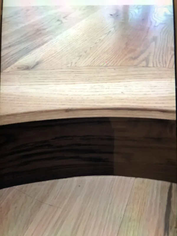 Curved timber detail meeting a pale wood floor