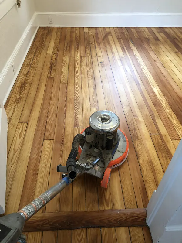 Floor edger on golden oak beside white trim