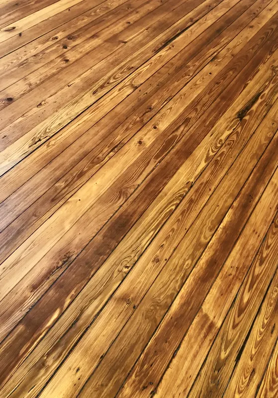 Warm reddish heart pine boards running diagonally with deep figured grain
