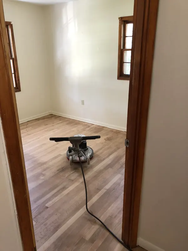 Sander at work in a bright room viewed through a doorway