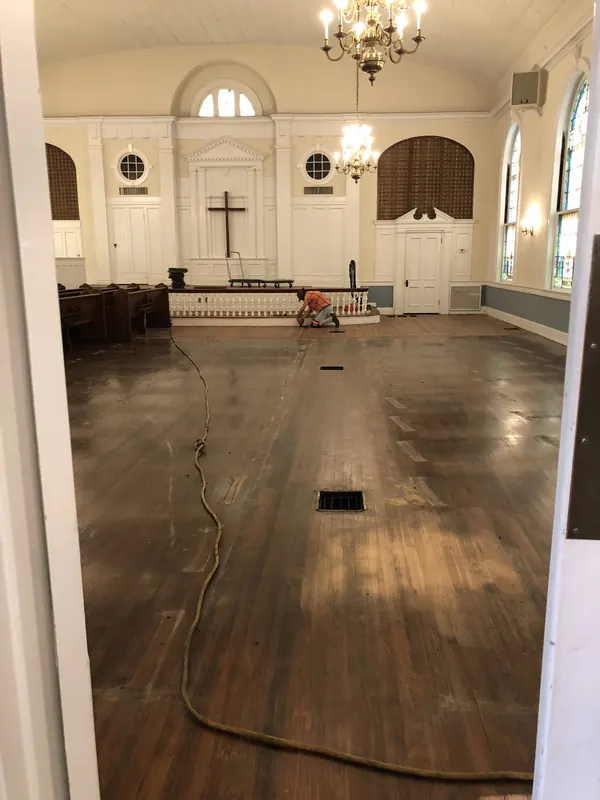 Church interior with pews removed and floor mid-refinish