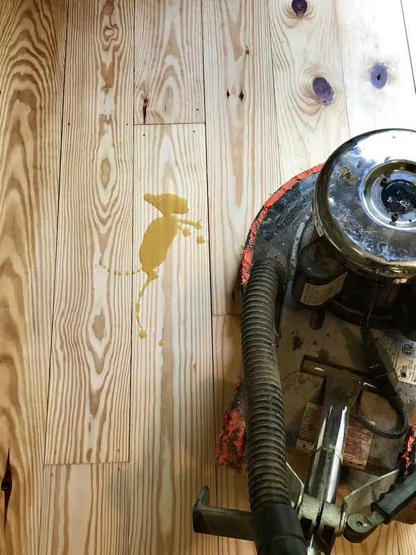 Drum sander parked on half-sanded heart pine