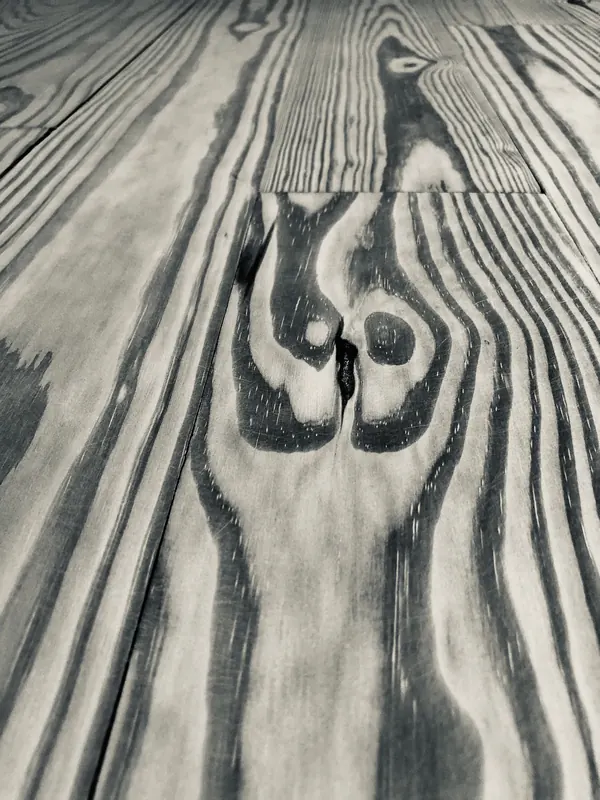 Dramatic dark flame-shaped grain figure in a pale sanded board