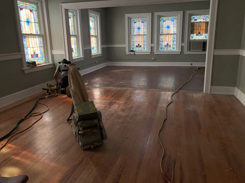 Drum sander in a large room lined with leaded stained-glass windows