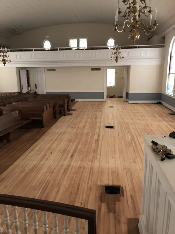 Bright church hall with pews and a pale refinished floor