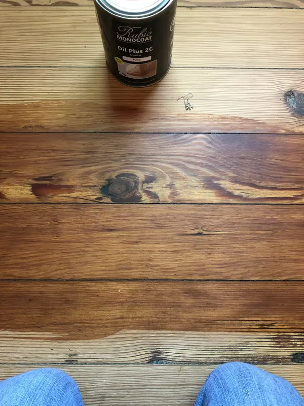 Finish can standing on freshly coated dark pine boards