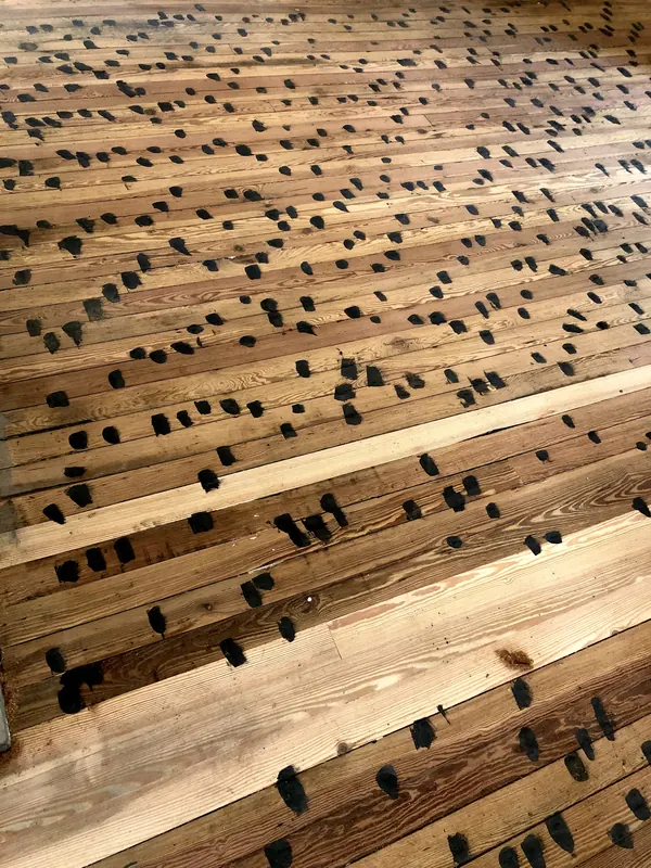 Floor studded with rows of dark square wooden pegs