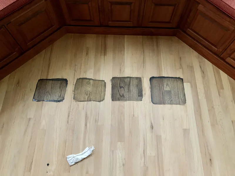 Four rectangular wood patches set into a pale oak floor