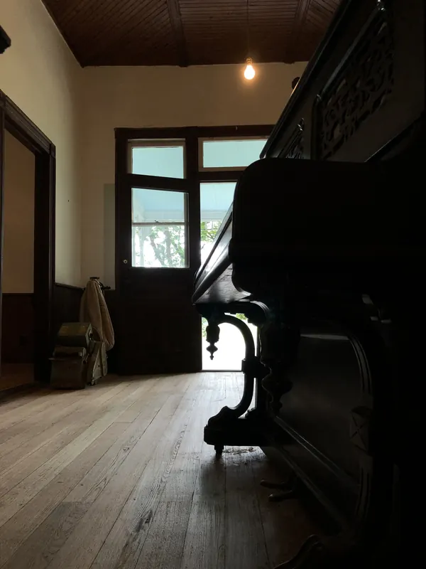 Dark room with a piano standing on pale grey-toned floor