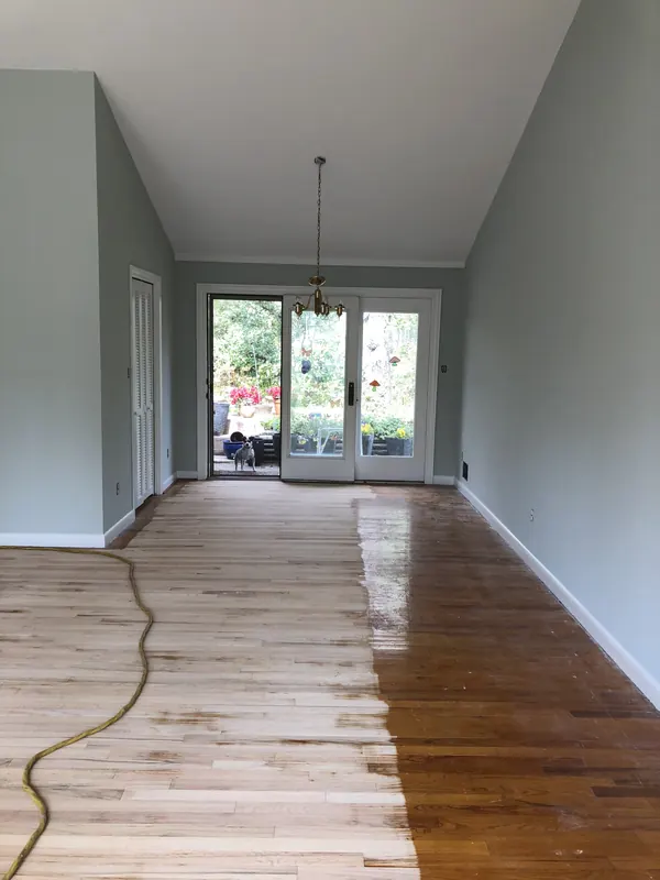 Long room with new floor leading to french doors and greenery