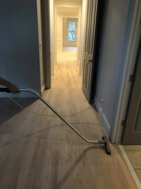Hallway with a vacuum hose trailing across a pale floor