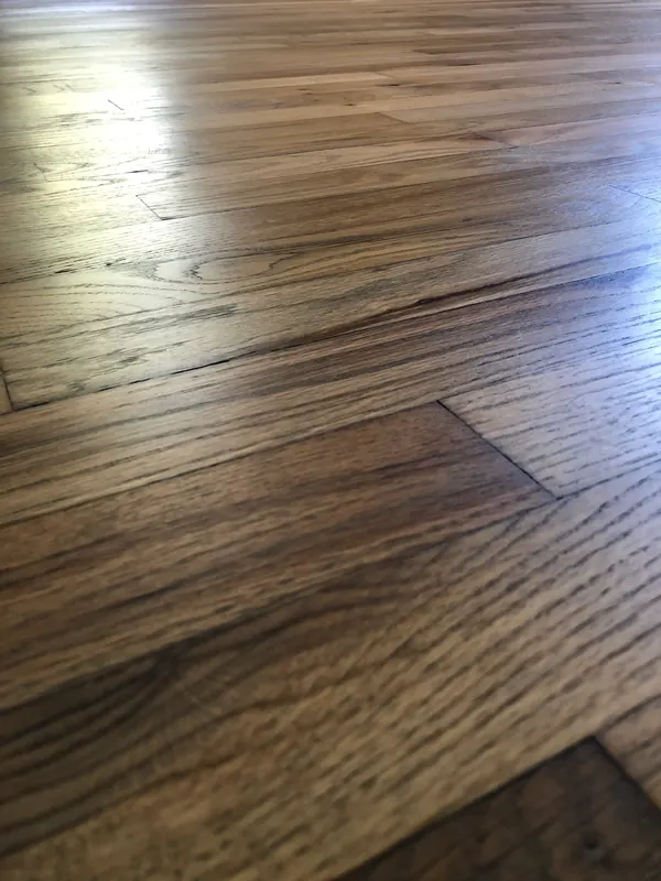 Dark stained floor with a lighter replacement board blended in