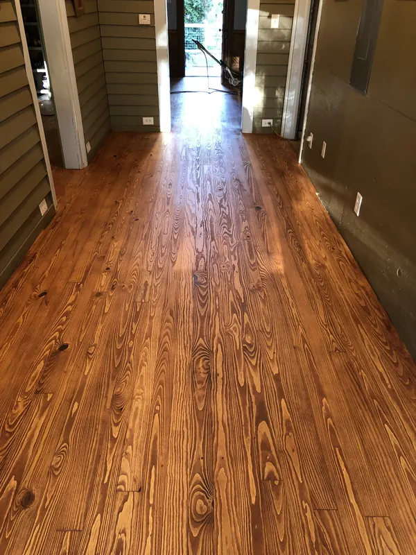 Glowing orange heart pine running down a hallway