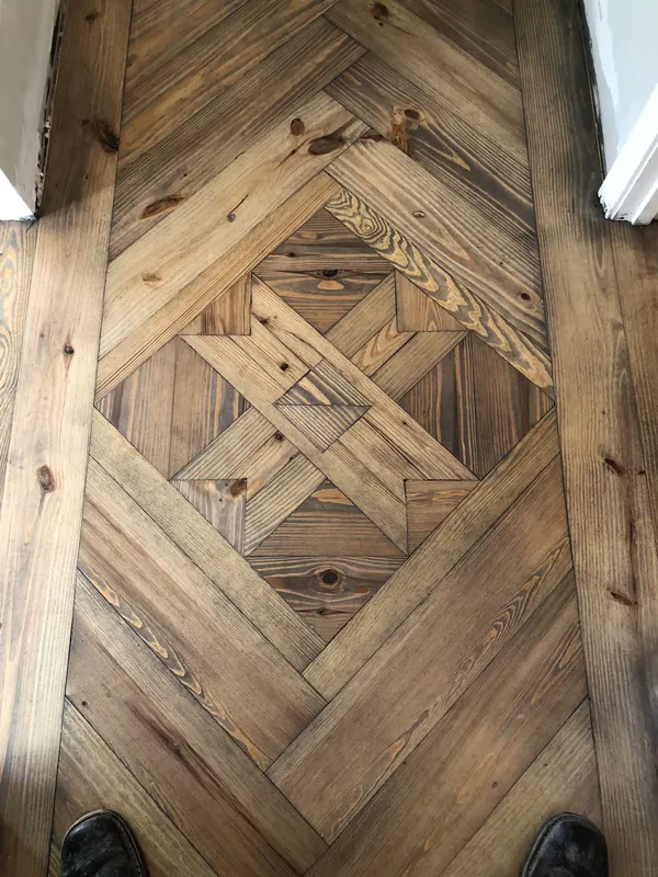 Diamond marquetry panel set into a reclaimed timber floor