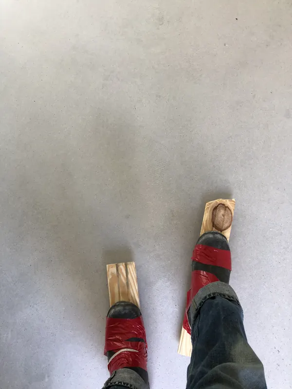 Boards and boots on a bare concrete floor