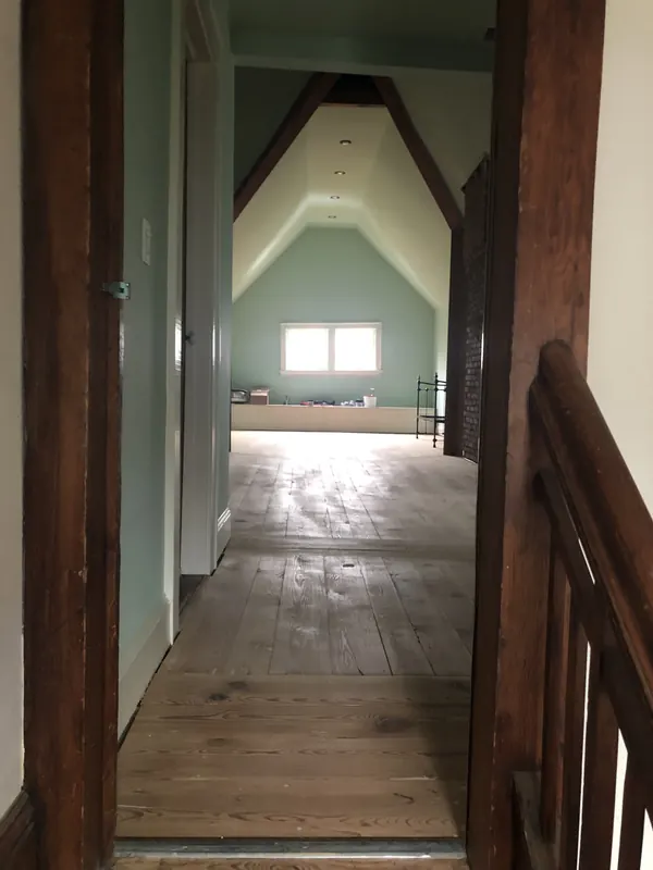 View past a dark timber post to a bright hallway