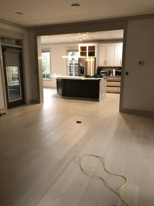 Modern kitchen and island above wide pale oak boards