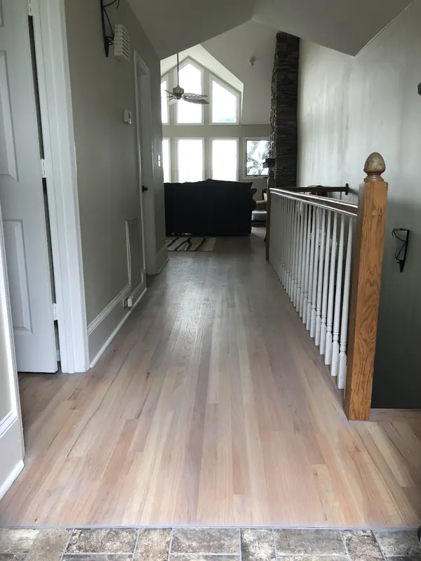 Pale wide-plank floor running past a timber balustrade