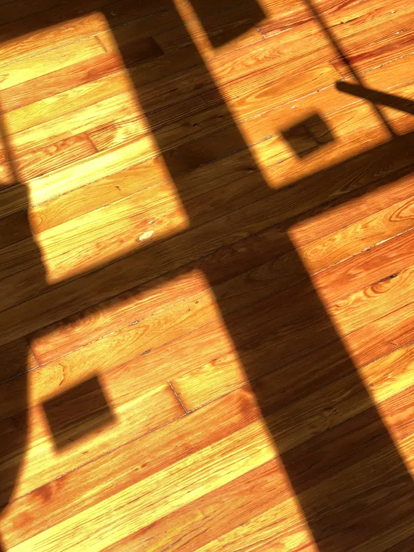 Strong window shadow cast over glowing orange heart pine