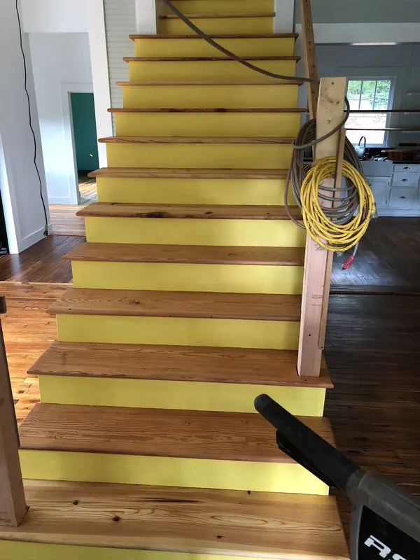 Staircase with yellow-painted treads part stripped