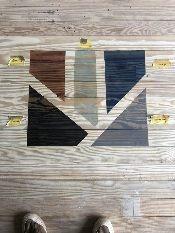 Deck boards with a painted arrow design and tape markers