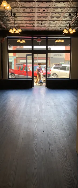 Glossy floor running toward a storefront window and street