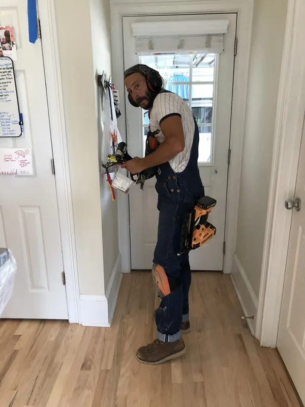 Craftsman in overalls standing in a finished hallway