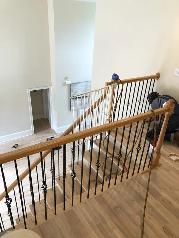 Stair landing with balustrade above a warm wood floor