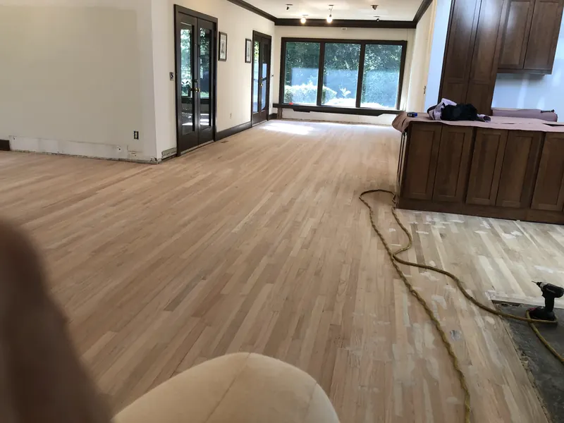 Wide living space with pale oak running past a kitchen island
