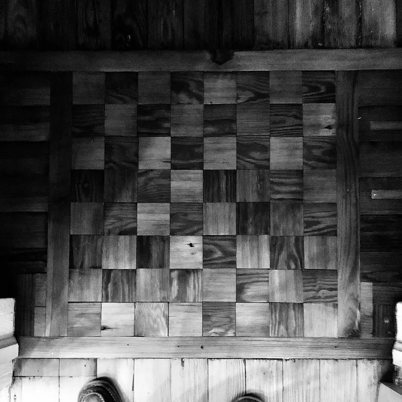Black and white photograph of a checkerboard parquet floor