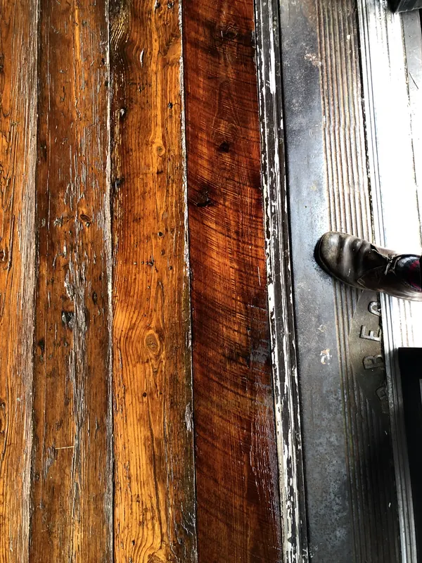 Glowing orange heart pine boards beside a dark doorway