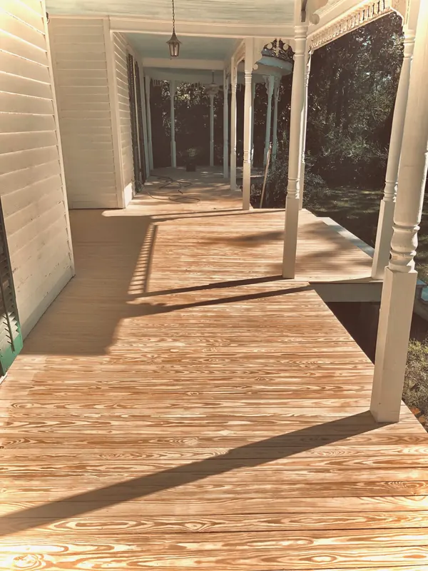 Covered porch with light falling across new boards