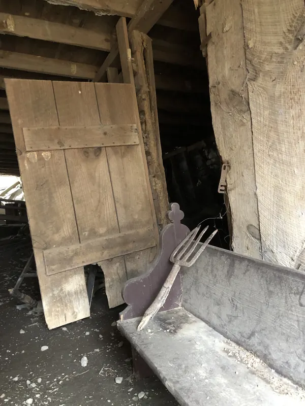 Interior of an old structure with weathered boards leaning