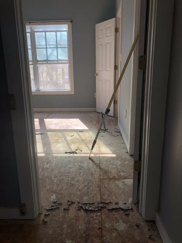 Doorway with damaged floorboards partly lifted