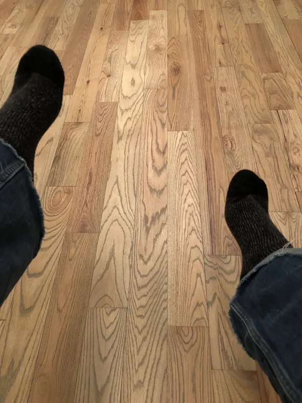 Boots on warm heart pine boards with strong grain