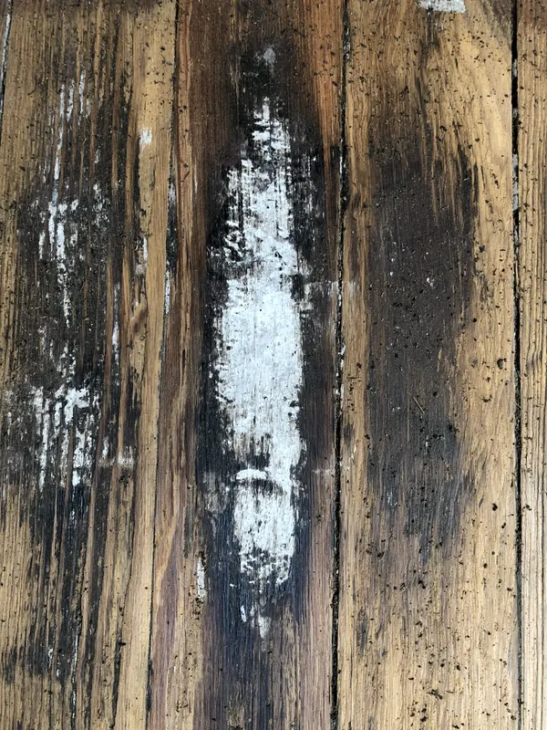 Weathered dark boards with remnants of white paint