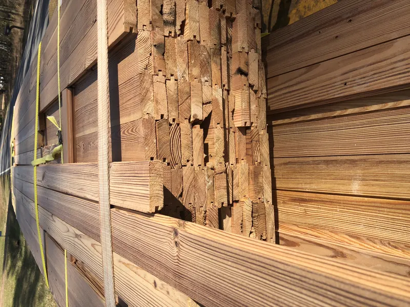 Old building being dismantled with reclaimed boards stacked alongside
