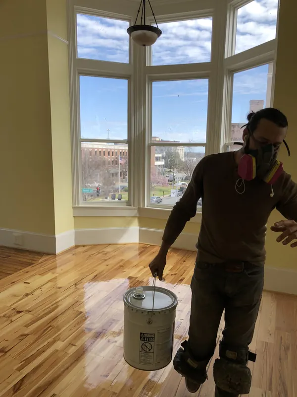 Craftsman with a finish bucket in a curved bay window room