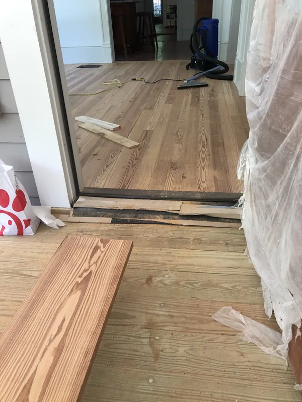 Fresh pine board resting on a floor mid-repair