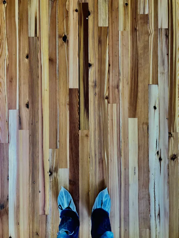 Reclaimed multi-toned boards seen from above with shoe covers