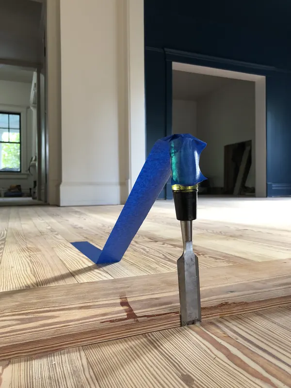 Blue-handled tool standing on a pale new floor