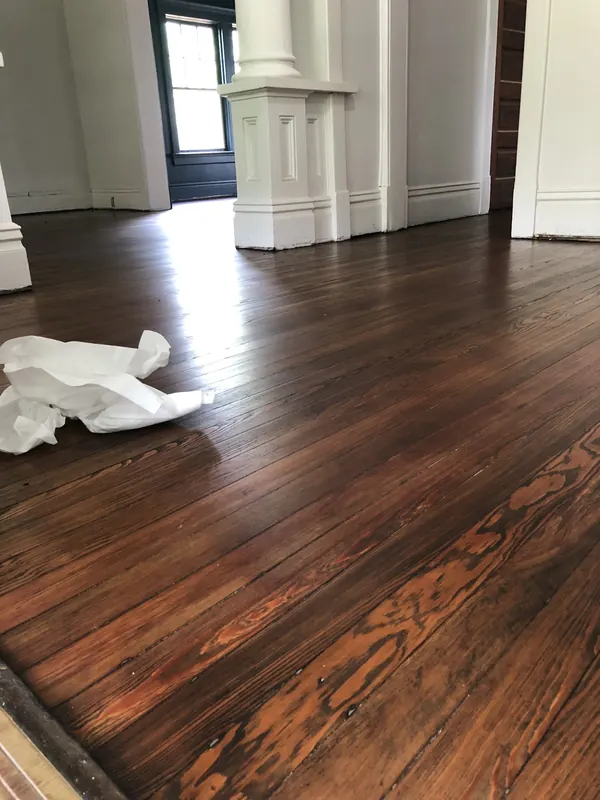 Dark glossy oak floor beside a white fireplace