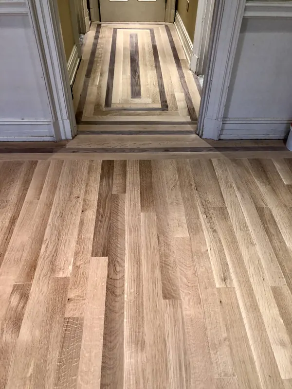 Pale floor running down a hallway toward a bright doorway