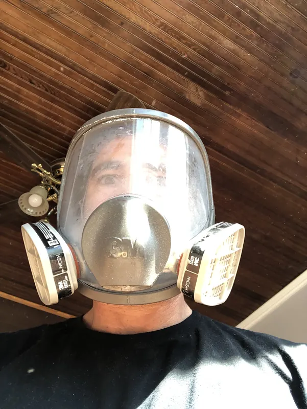 Craftsman wearing a full-face respirator indoors