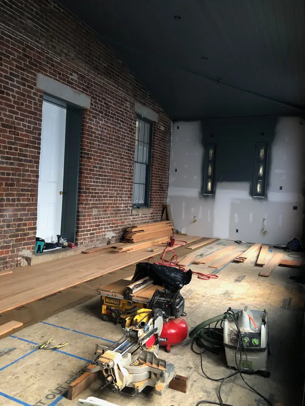 Brick-walled loft with flooring being laid