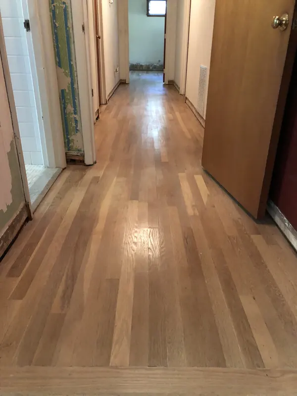 Glossy hallway floor running toward a bright room