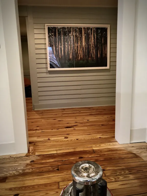 Room with framed art above a floor being refinished